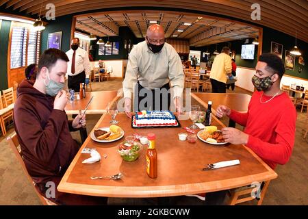 Airman 1st Class Dawson Sigetti (a sinistra) e Airman 1st Class John Moore, entrambi con 75th Force Support Squadron, sono serviti una torta di compleanno da Moses Thompson, 75th FSS Smoutment Flight Chief, presso l'Hillcrest Dining Facility 3 marzo 2021, presso la Hill Air Force base, Utah. Un nuovo programma di pasto di compleanno è stato introdotto per permettere ai residenti dormitorio e gli ospiti di celebrare ricevendo uno speciale pasto di compleanno senza costi e torta presso la sala da pranzo. Foto Stock