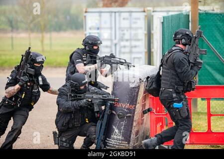 I poliziotti del Dipartimento di polizia del Northamptonshire, avanzano le loro posizioni durante un esercizio di formazione sul campo alla RAF Croughton, Inghilterra, 3 marzo 2021. L'NHPD ha utilizzato il complesso di addestramento squadron delle forze di sicurezza 422d per rafforzare le loro tattiche e tecniche. Eventi come questo contribuiscono a rafforzare la partnership locale tra il 422d SFS e il NHPD. Foto Stock