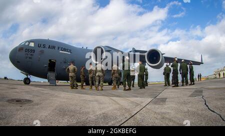 I Marines USA con Marine Heavy Helicopter Squadron (HMH) 465 preparano a scaricare un elicottero CH-53E Super Stallion da un aereo C-17 Globemaster III con la Guardia Nazionale aerea dell'Alaska su MCAS Futenma, Okinawa, Giappone, 4 marzo 2021. Il CH-53E è stato trasferito dalle Hawaii a Okinawa in supporto di Force Design 2030. Foto Stock