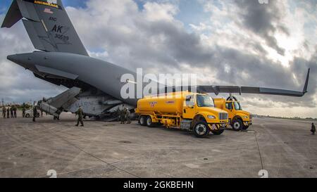 I Marines USA con Marine Heavy Helicopter Squadron (HMH) 465 scaricano un elicottero CH-53E Super Stallion da un aereo C-17 Globemaster III con la Guardia Nazionale aerea dell'Alaska su MCAS Futenma, Okinawa, Giappone, 4 marzo 2021. Il CH-53E è stato trasferito dalle Hawaii a Okinawa in supporto di Force Design 2030. Foto Stock