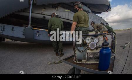 I Marines USA con Marine Heavy Helicopter Squadron (HMH) 465 scaricano un elicottero CH-53E Super Stallion da un aereo C-17 Globemaster III con la Guardia Nazionale aerea dell'Alaska su MCAS Futenma, Okinawa, Giappone, 4 marzo 2021. Il CH-53E è stato trasferito dalle Hawaii a Okinawa in supporto di Force Design 2030. Foto Stock