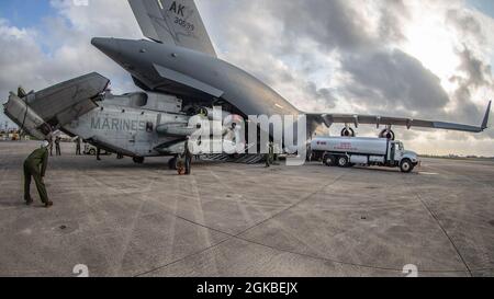 I Marines USA con Marine Heavy Helicopter Squadron (HMH) 465 scaricano un elicottero CH-53E Super Stallion da un aereo C-17 Globemaster III con la Guardia Nazionale aerea dell'Alaska su MCAS Futenma, Okinawa, Giappone, 4 marzo 2021. Il CH-53E è stato trasferito dalle Hawaii a Okinawa in supporto di Force Design 2030. Foto Stock