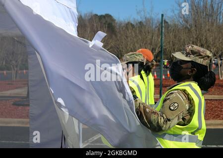 Cinquanta soldati della Guardia Nazionale della Carolina del Nord si dispiegano nell'arena PNC per le operazioni COVID-19 a Raleigh, Carolina del Nord, 4 marzo 2021. I soldati assegnati alla 30a Armored Brigade Combat Team del NCNG e alla 113esima Brigata sostenente hanno diretto il traffico dei veicoli e fornito supporto logistico e amministrativo al personale e ai volontari della Wake County Emergency Management. Foto Stock
