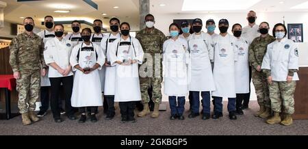 Sala da pranzo e centro fitness gli Airmen del 786th Force Support Squadron posano per una foto con i loro allenatori, giudici e leadership dopo aver completato una gara di cook-off alla stazione aerea di Kapaun, Germania, 4 marzo 2021. Gli Airmen attualmente assegnati alle strutture per il fitness hanno superato la sala da pranzo Airmen per vincere la competizione culinaria del 2021. Foto Stock