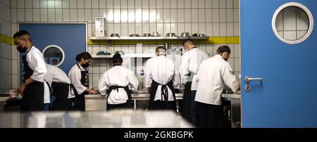 Gli airman del 786th Force Support Squadron lavorano nelle loro stazioni durante una gara di cook-off alla stazione aerea di Kapaun, Germania, 4 marzo 2021. Gli Airmen sono stati istruiti da assistenti arruolati, che sono responsabili per assistere i responsabili senior con una serie di compiti, tra cui la pianificazione, la preparazione e il catering eventi. Foto Stock