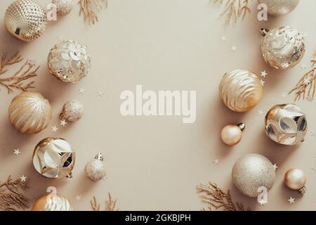Composizione di Natale. Cornice in palle dorate su sfondo beige pastello. Natale, inverno, nuovo anno concetto. Disposizione piatta, vista dall'alto Foto Stock
