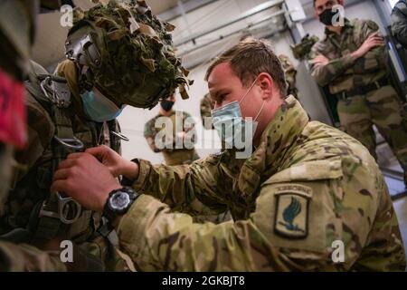 Un jumpmaster dell'esercito degli Stati Uniti assegnato alla 173a Brigata Airborne istruisce i paracadutisti francesi dell'8 Regiment Parachutiste D'Infanterie de Marine, 11 Brigade Parachutiste nell'indossare e montare un paracadute T-11 come parte dell'esercizio Rock Topside II presso il Joint Multinational Readiness Centre di Hohenfels, Germania il 5 marzo 2021. La 173a Brigata Airborne è la forza di risposta di emergenza dell'esercito degli Stati Uniti in Europa, che fornisce forze rapidamente dispiegabili alle aree di responsabilità dell'Europa degli Stati Uniti, dell'Africa e del comando centrale. Forward schierato in Italia e Germania, la brigata Foto Stock