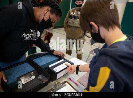 U.S. Air Force staff Sgt. Crystal Whitehead, 423a Security Forces Squadron non commissionato ufficiale in carica delle indagini, mostra una dimostrazione di impronte digitali a studenti di 4 e 5° grado presso la Royal Air Force Alconbury Middle High School, Inghilterra, 5 marzo 2021. I difensori delle forze di sicurezza hanno organizzato una dimostrazione per mostrare agli studenti un'esposizione di armi, una stazione di impronte digitali, McGruff the Crime Dog e un veicolo di pattuglia. Foto Stock