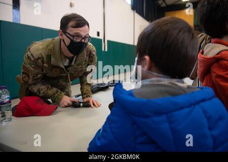 U.S. Air Force staff Sgt. David Ward, 423rd Security Forces Squadron non commissionato ufficiale in carica di armeria, mostra un'arma mostra agli studenti di 4 ° e 5 ° grado alla Royal Air Force Alconbury Middle High School, Inghilterra, 5 marzo 2021. I difensori delle forze di sicurezza hanno organizzato una dimostrazione per mostrare agli studenti un'esposizione di armi, una stazione di impronte digitali, McGruff the Crime Dog e un veicolo di pattuglia. Foto Stock