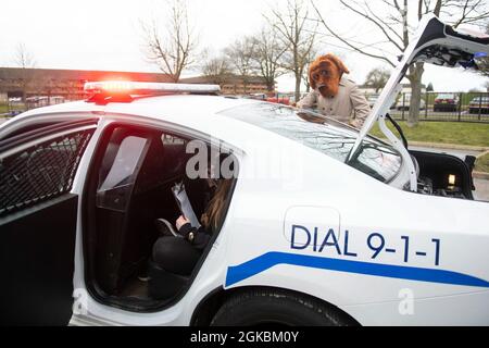 McGruff The Crime Dog, che collabora con il 423esimo Squadrone delle forze di sicurezza, mostra un veicolo di pattugliamento agli studenti di 4° e 5° grado presso la Royal Air Force Alconbury Middle High School, Inghilterra, 5 marzo 2021. I difensori delle forze di sicurezza hanno organizzato una dimostrazione per mostrare agli studenti un'esposizione di armi, una stazione di impronte digitali, McGruff the Crime Dog e un veicolo di pattuglia. Foto Stock