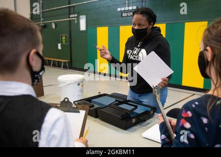 U.S. Air Force staff Sgt. Crystal Whitehead, 423a Security Forces Squadron non commissionato ufficiale in carica delle indagini, mostra una dimostrazione di impronte digitali a studenti di 4 e 5° grado presso la Royal Air Force Alconbury Middle High School, Inghilterra, 5 marzo 2021. I difensori delle forze di sicurezza hanno organizzato una dimostrazione per mostrare agli studenti un'esposizione di armi, una stazione di impronte digitali, McGruff the Crime Dog e un veicolo di pattuglia. Foto Stock