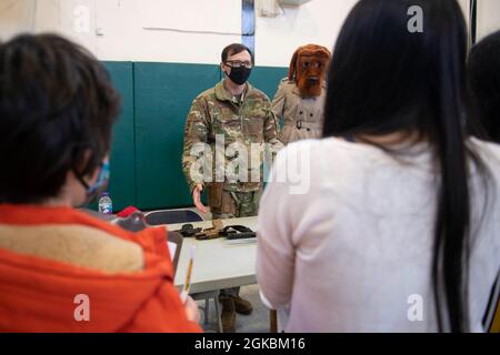 U.S. Air Force staff Sgt. David Ward, 423rd Security Forces Squadron non commissionato ufficiale in carica di armeria, mostra un'arma mostra agli studenti di 4 ° e 5 ° grado alla Royal Air Force Alconbury Middle High School, Inghilterra, 5 marzo 2021. I difensori delle forze di sicurezza hanno organizzato una dimostrazione per mostrare agli studenti un'esposizione di armi, una stazione di impronte digitali, McGruff the Crime Dog e un veicolo di pattuglia. Foto Stock