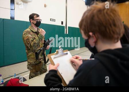 U.S. Air Force staff Sgt. David Ward, 423rd Security Forces Squadron non commissionato ufficiale in carica di armeria, mostra un'arma mostra agli studenti di 4 ° e 5 ° grado alla Royal Air Force Alconbury Middle High School, Inghilterra, 5 marzo 2021. I difensori delle forze di sicurezza hanno organizzato una dimostrazione per mostrare agli studenti un'esposizione di armi, una stazione di impronte digitali, McGruff the Crime Dog e un veicolo di pattuglia. Foto Stock