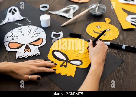 Mani di giovane donna con teschi di disegno, fantasmi e zucche per Halloween Foto Stock