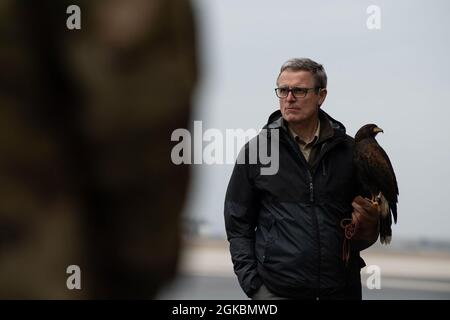 Jens Fleer, 52° base dell'ala dei combattenti falconer, tiene il suo falco, Jack, mentre parla con i membri dell'aeronautica statunitense del 726° Squadrone della mobilità aerea durante un briefing di Bird and Wildlife Aircraft Strike Hazard (BASH) al 726° AMS sulla base aerea di Spangdahlem, Germania, 5 marzo 2021. La formazione è stata condotta dal 52° Ufficio di sicurezza dell'ala dei combattenti al fine di ampliare la prevenzione dei disguidi intorno alla base. Foto Stock