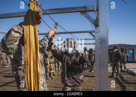 Un paracadutista francese assegnato a 8 Regiment Parachutiste D’Infanterie de Marine, 11 Brigade Parachutiste passa la sua linea statica alla sua sicurezza durante la formazione aerea sostenuta come parte di Exercise Rock Topside II presso il Joint Multinational Readiness Centre di Hohenfels, Germania, il 6 marzo 2021. La 173a Brigata Airborne è la forza di risposta di emergenza dell'esercito degli Stati Uniti in Europa, che fornisce forze rapidamente dispiegabili alle aree di responsabilità dell'Europa degli Stati Uniti, dell'Africa e del comando centrale. Forward schierata in Italia e Germania, la brigata si allena regolarmente insieme agli alleati della NATO AN Foto Stock