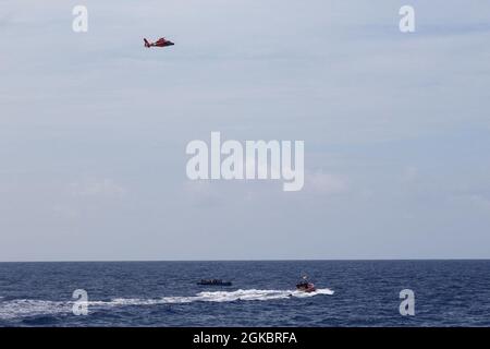 L'equipaggio della Cutter della Guardia Costiera Joseph Tezanos piccola barca e una Guardia Costiera MH-65 Delfino elicottero da Air Station Borinquen sono in scena con uno dei due clandestini migranti, da casi separati, che sono stati interdetti dal tagliatore in Mona passaggio acque 6 marzo 2021. I 58 migranti provenienti da entrambe le interdipendenze sono stati rimpatriati in mare in una nave della Repubblica Dominicana vicino alla Repubblica Dominicana 7 marzo 2021. Foto Stock