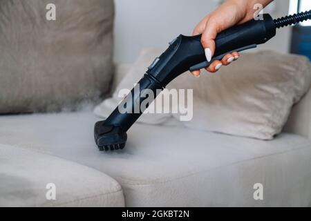 Pulizia a mano un divano con pulitore a vapore, concetto di pulizia della  casa Foto stock - Alamy