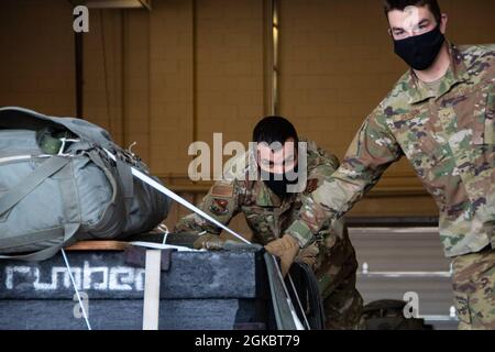 Tecnologia. SGT. John Bower, 120th Logistics Readiness Squadron Air Transport Cargo Processing NCOIC e Senior Airman Lawrence Gannon, 120th LRS Air Transport journeyman, spingere una piattaforma airdrop per attrezzature pesanti fuori da Hangar, 6 marzo 2021, Great Falls, Montana. Una piattaforma per attrezzature pesanti viene utilizzata nella formazione C-130 Hercules airdrop Operations. Foto Stock