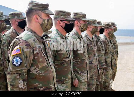 I soldati della Guardia Nazionale dell'esercito dell'Iowa assegnati alla squadra di monitoraggio di collegamento di Kilo 18, comando regionale-Est, forza del Kosovo, stanno in formazione durante una cerimonia di riconoscimento a Camp Bondsteel, Kosovo, l'8 marzo 2021. SGT. Spenser Sharp e SPC. A Cole Magnuson sono state assegnate monete Ryder Brigade per onorarli per aver fatto il possibile per aiutare i civili del Kosovo in caso di emergenza. Foto Stock