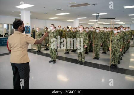 Aviation Machinist's Mate 1st Class Latasha Lawrence, un comandante della divisione di reclutamento, istruisce le reclute durante la pratica di perforazione all'interno di un compartimento delle caserme di reclutamento USS Triton al comando di addestramento di reclutamento. Più di 40,000 reclute si allenano ogni anno presso l’unico campo di stivali della Marina. Foto Stock