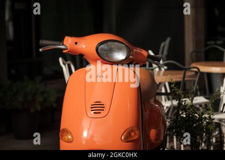 Scooter arancione in piedi fuori in una giornata di sole. Foto Stock