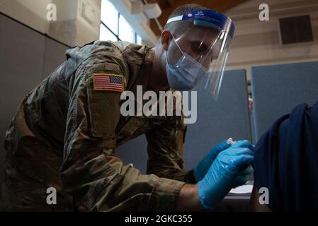 SPC dell'esercito degli Stati Uniti. Andrew Hannebaum, un nativo di Oxford, Ohio, e un medico assegnato al 531st Hospital Center, vaccina un membro della comunità presso il St. John the Baptist Roman Catholic Cathedral COVID-19 Community Vaccination Center di Jersey City, New Jersey, 9 marzo 2021. I membri del servizio di questo centro sono costituiti da marinai della Marina degli Stati Uniti e soldati dell'esercito degli Stati Uniti. Il comando del Nord degli Stati Uniti, attraverso l'Esercito del Nord degli Stati Uniti, rimane impegnato a fornire il supporto continuo e flessibile del Dipartimento della Difesa all'Agenzia federale di gestione delle emergenze come parte dell'intero governo Foto Stock