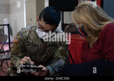 SPC dell'esercito degli Stati Uniti. Aian Foronda, un Oahu, Hawaii, nativo e infermiera assegnata al 531st Hospital Center, vagliano un membro della comunità presso il centro di vaccinazione comunitaria di San Giovanni Battista, gestito dallo stato, con il sostegno federale della cattedrale cattolica romana COVID-19 a Paterson, New Jersey, 9 marzo 2021. I membri del servizio di questo centro sono costituiti da marinai della Marina degli Stati Uniti e soldati dell'esercito degli Stati Uniti. Il comando del Nord degli Stati Uniti, attraverso l'esercito del Nord degli Stati Uniti, rimane impegnato a fornire il supporto continuo e flessibile del Dipartimento della Difesa all'Agenzia federale di gestione delle emergenze come parte dell'intera-of-government respon Foto Stock