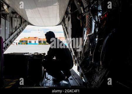 Una stazione aerea della Guardia Costiera Sacramento C-27J il membro dell'equipaggio Spartan lega i vaccini COVID-19 all'aeromobile di Oakland, California, 9 marzo 2021. I vaccini sono stati inviati dalla base Alameda a San Diego per essere distribuiti tra il personale della Guardia Costiera nell'area di San Diego. Foto Stock