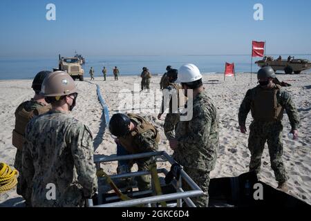VIRGINIA BEACH, Va. marinai assegnati al Battaglione di costruzione anfibio (ACB) 2, e Beachmaster Unit (BMU) 2, collegare un tubo all'unità di interfaccia Spiaggia durante l'addestramento del sistema di trasferimento di liquidi di massa anfibio (ABLTS) alla base di spedizione mista Little Creek il 10 marzo 2021. La formazione è stata condotta in preparazione delle future operazioni di Joint Logistics Over-the-Shore. Foto Stock