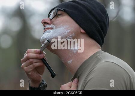 Un paratrooper dell'esercito degli Stati Uniti assegnato alla prima squadra di combattimento di Brigade, 82nd divisione di Airborne rasa il suo volto durante la rotazione 21-05 al centro di addestramento di preparazione Unito su Fort Polk, la., 10 marzo 2021. La rotazione serve a migliorare la brigata e la disponibilità all'implementazione dell'unità di supporto. Foto Stock