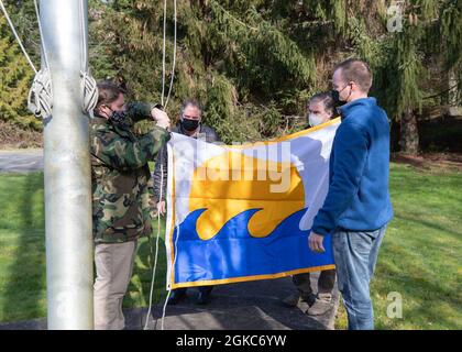 210310-N-UV347-008 KEYPORT, Washington (10 marzo 2021) – i membri della Divisione Naval Undersea Warfare Center della Divisione Infrastructure di Keyport si preparano a sollevare il Segretario della Bandiera Navy Energy dopo aver vinto il SECNAV Energy Excellence Award nella categoria Small installation per il 2020. In riconoscimento del risultato, il comando è autorizzato a battere la bandiera per un anno fino all'anniversario della sua data di assegnazione. Il premio è assegnato alle installazioni della Marina che eccellono nella gestione dei programmi energetici, nel contributo alla sicurezza energetica, nel miglioramento della prontezza e nella capacità di missione. Foto Stock