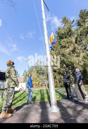 210310-N-UV347-010 KEYPORT, Washington (10 marzo 2021) – i membri della Divisione Naval Undersea Warfare Center Divisione Infrastructure Keyport sollevano il Segretario della Bandiera Navy Energy dopo aver vinto il SECNAV Energy Excellence Award nella categoria Small installation per il 2020. In riconoscimento del risultato, il comando è approvato per volare la bandiera per un anno fino all'anniversario della sua data di assegnazione. Il premio è assegnato alle installazioni della Marina che eccellono nella gestione dei programmi energetici, nel contributo alla sicurezza energetica, nel miglioramento della prontezza e nella capacità di missione. Foto Stock