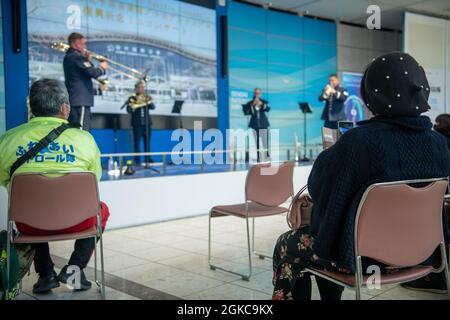 I membri del pubblico giapponese guardano l'esibizione della Air Force Band del Pacifico all'Aeroporto di Sendai. La band è in tournée nella Prefettura di Miyagi a sostegno del 10° anniversario del Grande terremoto e dello tsunami del Giappone Orientale. Foto Stock