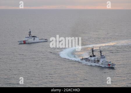 L'equipaggio della Guardia Costiera Cutter Stratton (WMSL 752) allevia l'equipaggio della Guardia Costiera Cutter Douglas Munro (WHEC 724) nel mare di Bering, 12 marzo 2021. Il Douglas Munro è stato l’ultimo taglierino di resistenza alta 378 metri della Guardia Costiera ed è stato sollevato da Stratton concludendo la loro pattuglia finale prima di essere smantellato il 24 aprile 2021. Foto della Guardia Costiera degli Stati Uniti. Foto Stock