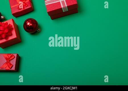 Composizione di baubles con regali e spazio di copia su sfondo verde Foto Stock