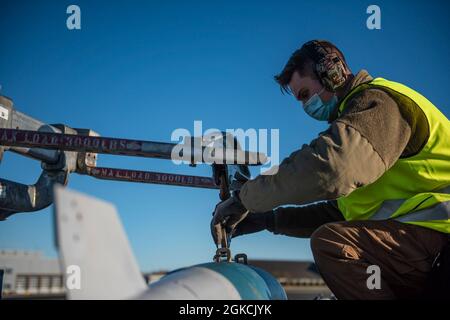 Un capo della squadra dell'equipaggio di carico di armi assegnato al 9° Squadrone della bomba di spedizione assicura un'unità fittizia di bomba ad un jammer MHU-83 alla stazione dell'aeronautica di Ørland, Norvegia, 13 marzo 2021. I membri del team dell'equipaggio di carico delle armi hanno caricato otto BDU in un B-1B Lancer prima di condurre una missione di addestramento della Bomber Task Force Europe. Foto Stock