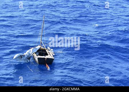 Una nave rustica che trasportava migranti cubani galleggia a circa 50 miglia a sud-est delle Bahamas, 14 marzo 2021. L'equipaggio della Guardia Costiera Cutter Charles David Jr. Rimpatriò i migranti a Cuba, 17 marzo 2021. Foto Stock