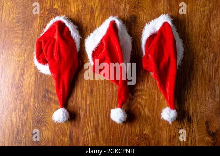 Composizione di cappelli babbo natale e spazio copia su sfondo di legno Foto Stock