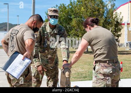 SGT. 1a classe Kendell Richmond (centro) istruisce SPC. Jessie Weinman (a sinistra) e SPC. Alfonzo Perez (a destra) su come innescare una pompa dell'acqua grezza durante un corso di funzionamento dell'acqua fuori del 210o Istituto di formazione Regionale, 16 marzo 2021. Gli studenti del 210o RTI, classe #21-102, conducono operazioni idriche su un'unità di purificazione dell'acqua ad osmosi inversa (ROWPU) da 3,000 galloni all'ora. Questa classe comprende soldati provenienti da California, Montana, West Virginia, Alabama e Missouri. Foto Stock