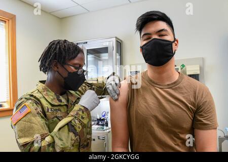 210216-N-ZU848-0147 CHINHAE, Repubblica di Corea (Mar. 16, 2021) SPC. Nedjie Joseph somministra la seconda dose del vaccino COVID-19 all'operatore di apparecchiatura 2a classe ed Natividad alla clinica di salute della filiale della Marina Chinhae. Marinai assegnati alla Clinica sanitaria della filiale della Marina Chinhae e soldati assegnati al 549th Medical Hospital Center, 65th Medical Brigade ha somministrato la seconda dose del vaccino COVID-19, su base completamente volontaria, a marinai che sono stati identificati come personale di prima linea dai loro comandi. Foto Stock