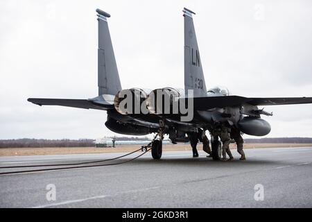 Gli airmen assegnati al 48esimo lavoro di manutenzione di velivolo Squadron per liberare il cavo dal gancio di coda di un 492nd Fighter Squadron F-15E Sciopero Eagle durante una certificazione di Kit di arresto di barriera a Ämari Air base, Estonia, 17 marzo 2021. Il BAK è certificato annualmente per testare la stabilità e l'efficacia del sistema, che funge da meccanismo di frenatura per arrestare l'aeromobile in caso di emergenza che impedirebbe all'aeromobile di effettuare un atterraggio standard. Foto Stock