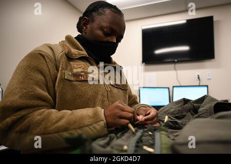 US Air Force Airman 1st Class Deasya Doyle, un apprendista 354th Operation Support Squadron Aircrew Flight Equipment (AFE), ispeziona un indumento scheletrico a gravità più bassa sulla base dell'aeronautica Eielson, Alaska, 17 marzo 2021. Gli specialisti AFE hanno la responsabilità di garantire che tutte le attrezzature di volo e di sicurezza siano perfettamente funzionanti. Foto Stock