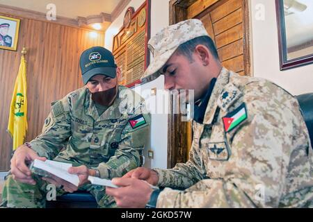 Esercito degli Stati Uniti Sgt. 1a Classe Davin Schultz, un 36esimo sparatutto della Divisione di fanteria di Manor, Texas, confronta le guide tascabili con il comandante delle forze Armate giordane della Unit Tank Company del 3rd Border Guard Group, CPT. Salem Abu Nwaer, 17 marzo 2021. Task Force i soldati spartani della Divisione Tactical- Giordania hanno consigliato e assistito i soldati del 3° gruppo di Guardia di confine nella loro area di operazioni con piccole tattiche di squadra, abilità del personale e l'empowerment dei loro ufficiali non commissionati. Questa opportunità contribuisce a migliorare le competenze, l'interoperabilità e la capacità dei partner, e rafforza la durabilità Foto Stock