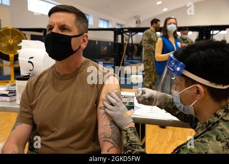 YOKOSUKA, Giappone (18 marzo 2021) — il comandante Derek Mullenhour, comandante, Fleet Activities il comandante del comando Yokosuka (CFAY), riceve il vaccino unico Johnson & Johnson COVID-19 dall'ospedale Corpsman Keanu Baes durante una distribuzione del vaccino COVID-19 al Nido del CFAY Hawk. I membri del servizio assegnati ai comandi CFAY e tenant hanno ricevuto il vaccino ad un colpo durante la distribuzione del vaccino. Per più di 75 anni, CFAY ha fornito, mantenuto e gestito le strutture e i servizi di base a sostegno delle forze navali dispiegate in avanti della 7th Fleet degli Stati Uniti, comandi locatari, e thous Foto Stock