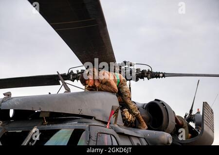 I manutentori del 66a squadra di salvataggio e del 855 squadra di manutenzione di aeromobili di stanza alla base dell'aeronautica di Nellis preparano gli elicotteri HH-60 per il paravento Hawk per l'addestramento che viene condotto al centro di addestramento di combattimento di Orchard in Idaho, 19 marzo 2021. Il 66 RQS sta lavorando con il 190° Fighter Squadron e più altri squadroni di salvataggio durante un evento di 10 giorni di allenamento da Gowen Field all'OCTC. Foto Stock