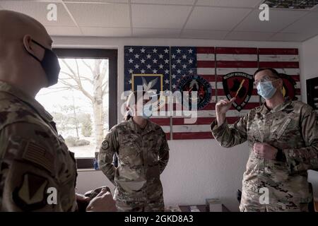 U.S. Air Force Tech. SGT. Samantha Williams, 86th Security Forces Squadron standardizzazione e valutazione non commissionato ufficiale in carica, centro, impara che è Airlifter della settimana da Briga. Gen. Josh Olson, 86° comandante dell'Ala Airlift, a sinistra, e Capo Maestro Sgt. Ben Burk, 86° responsabile SFS, Right, presso la base aerea di Ramstein, Germania, 18 marzo 2021. Il programma Airlifter of the Week riconosce gli individui che, grazie al duro lavoro e alla dedizione, fanno dell’86th AW la porta d’ingresso dell’Air Force nel mondo. Foto Stock