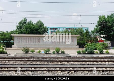 Ritratti di Kim Ll-Sung e Kim Jong adornano ogni treno stazione ferroviaria in Corea del Nord. Spesso con le citazioni della loro saggezza accanto a loro. Foto Stock