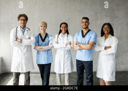 Team medico multirazziale che si pone in clinica mentre ha team-building Foto Stock