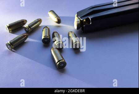 pallottole di parabellum di calibro 9mm isolate con luce radente accanto ad una rivista di munizioni a pistola Foto Stock